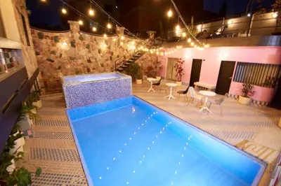 a swimming pool with lights and tables and chairs at Brana by Bernalo Hotels in Medellín