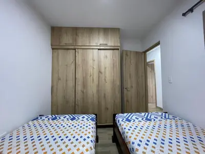 a bedroom with two beds and a wooden cabinet at Vista montaña Guatape by Hope in Guatapé