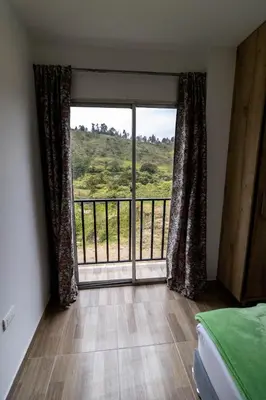 a bedroom with a large window with a view at Vista montaña Guatape by Hope in Guatapé