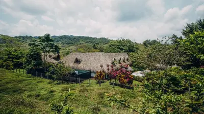 an old house in the middle of a field at Makenke Hostel By Los Colores Ecoparque in Doradal