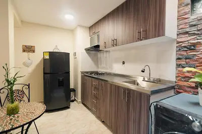 a kitchen with a sink and a black refrigerator at Rinconcito Encantador in Medellín