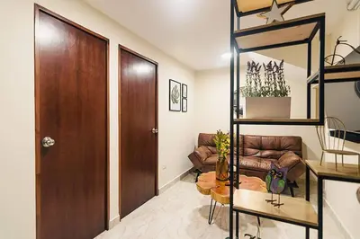a living room with a couch and a wooden door at Rinconcito Encantador in Medellín