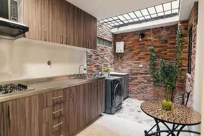 a kitchen with a table and a brick wall at Rinconcito Encantador in Medellín