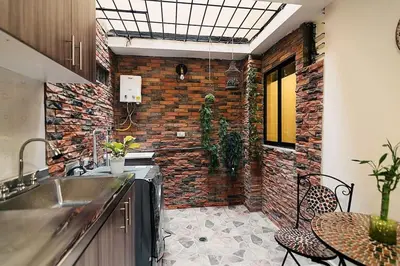 a kitchen with a sink and a brick wall at Rinconcito Encantador in Medellín