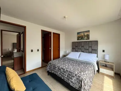 a bedroom with a large bed and a door to a bathroom at MARGARETH in Manizales