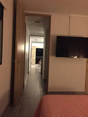 a room with a hallway with a bed and a television at Hermosa vista! Mejor ubicación! in Medellín