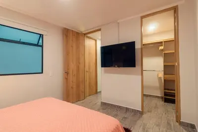 a bedroom with a bed and a flat screen tv at Hermosa vista! Mejor ubicación! in Medellín