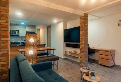 a living room with a couch and a table and a television at Hermosa vista! Mejor ubicación! in Medellín