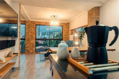 a kitchen and living room with a coffee maker on a table at Hermosa vista! Mejor ubicación! in Medellín