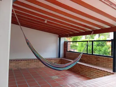 a hammock hanging in a room with windows at Cabaña con aire acondicionado San Jeronimo in San Jerónimo