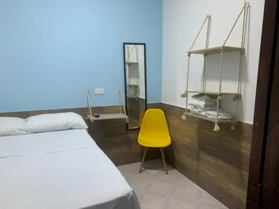 a room with a bed and a yellow chair at Confortable Habitación en Apartamento Amoblado Jardin in Jardin