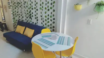 a white table with yellow chairs and a blue couch at Confortable Habitación en Apartamento Amoblado Jardin in Jardin