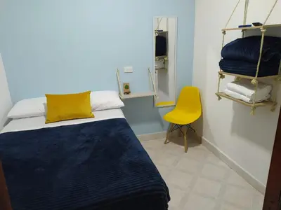 a bedroom with a bed and a yellow chair at Confortable Habitación en Apartamento Amoblado Jardin in Jardin
