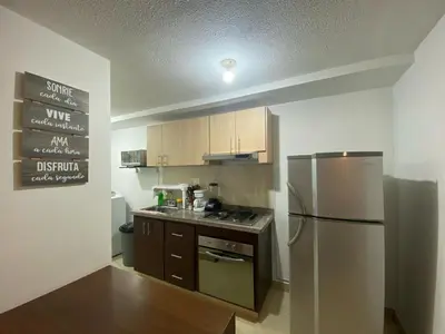 a kitchen with a stainless steel refrigerator and wooden cabinets at GIBRALTAR in Manizales