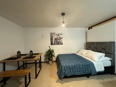 a bedroom with a bed and a table and a desk at GIBRALTAR in Manizales
