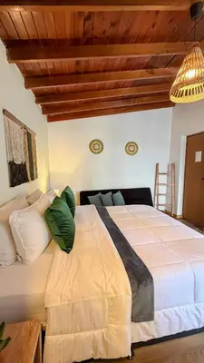 a bedroom with a large bed and a wooden ceiling at Luum Casa Hotel Manila in Medellín