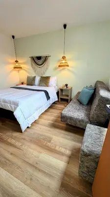 a bedroom with a bed and a couch at Luum Casa Hotel Manila in Medellín