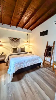 a bedroom with a bed and a wooden ceiling at Luum Casa Hotel Manila in Medellín