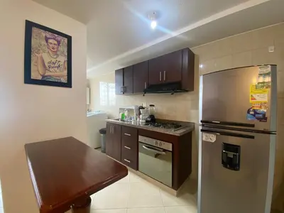 a kitchen with a refrigerator and a table in it at KOROLOVA in Manizales