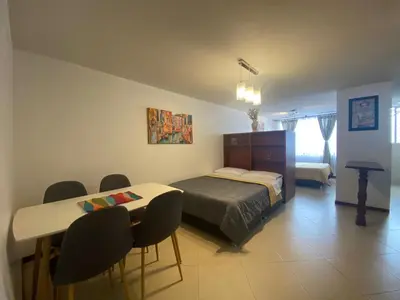 a bedroom with a bed and a table and chairs at KOROLOVA in Manizales