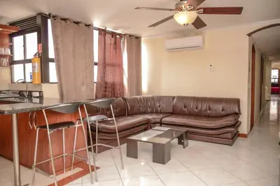 a living room with a brown leather couch and a table at Calle 8 Suites in Medellín