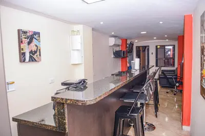 a bar in a room with chairs and a counter at Calle 8 Suites in Medellín