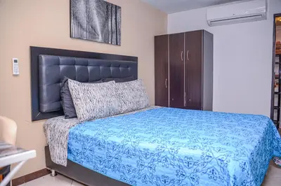 a bedroom with a bed with a blue comforter at Calle 8 Suites in Medellín