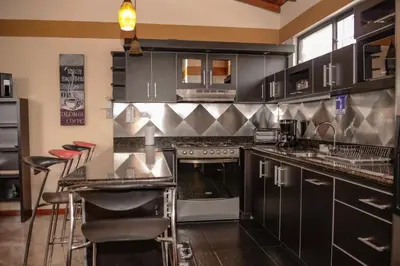 a kitchen with stainless steel appliances and black cabinets at Calle 8 Suites in Medellín