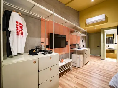 a kitchen with white cabinets and a tv in a room at The Somos Flats Provenza in Medellín