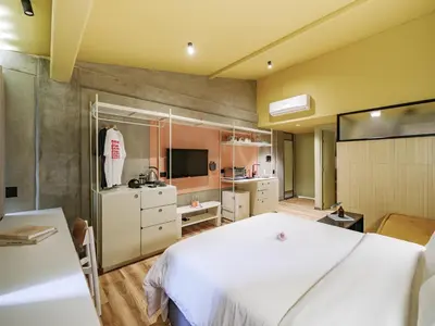 a bedroom with a white bed and a kitchen at The Somos Flats Provenza in Medellín
