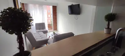 a living room with a table and chairs and a television at Hermoso Apartamento Ubicado en Zona Céntrica de Medellín in Medellín