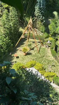 a wooden triangle in the middle of a garden at Ibuku Hotel Guatapé - Chalets in Guatapé