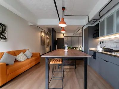 a kitchen and living room with a table and a couch at Lauret Lofts by Wynwood House in Medellín
