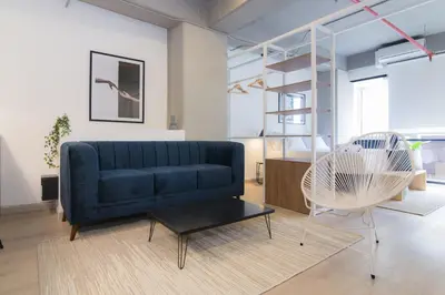 a living room with a blue couch and a chair at Lauret Lofts by Wynwood House in Medellín