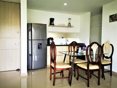 a kitchen with a table and chairs and a refrigerator at Apartment cerca centro histórico Sta Fe Antioquia in Santa Fe de Antioquia