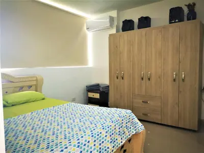 a bedroom with a bed and a wooden cabinet at Apartment cerca centro histórico Sta Fe Antioquia in Santa Fe de Antioquia