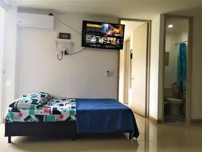 a bedroom with a bed with a tv on the wall at Apartment cerca centro histórico Sta Fe Antioquia in Santa Fe de Antioquia