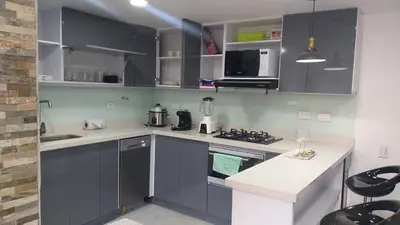 a kitchen with gray cabinets and a white counter top at Andy in Bello
