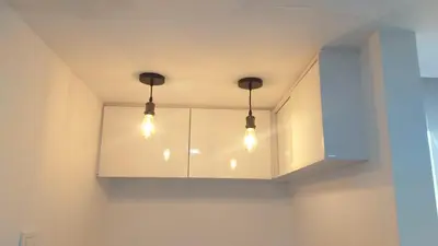 a kitchen with white cabinets with lights on it at Andy in Bello