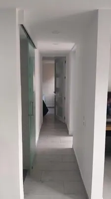 a hallway in a room with white walls and a door at Andy in Bello