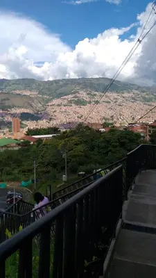 a person sitting on a fence looking at a city at Andy in Bello