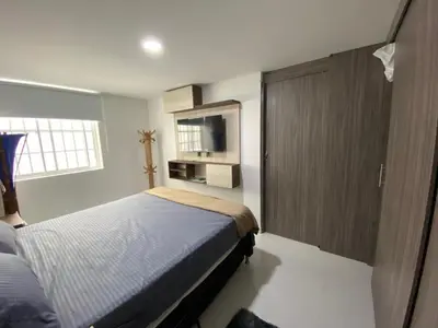 a bedroom with a bed and a cabinet and a television at Conquistadores Romantic, Medellín in Medellín