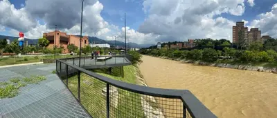 a bridge over a river with people walking on it at Conquistadores Romantic, Medellín in Medellín
