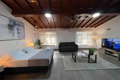 a bedroom with a bed and a couch and a tv at Apt Palos Altos Poblado; caminando de restaurantes in Medellín