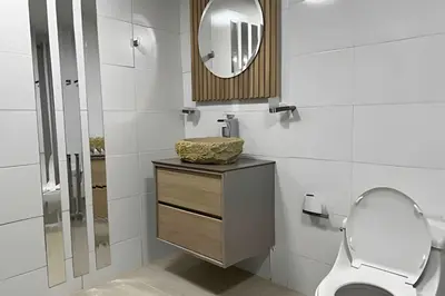 a bathroom with a toilet and a mirror at Apt Palos Altos Poblado; caminando de restaurantes in Medellín