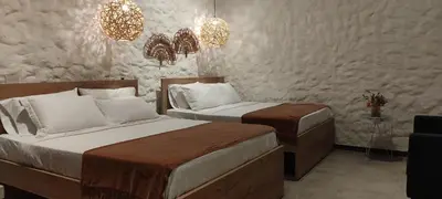 a bedroom with two beds and a table and chandeliers at La Casa de Nelly - Medellín in Medellín