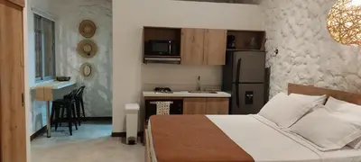 a bedroom with a bed and a small kitchen at La Casa de Nelly - Medellín in Medellín