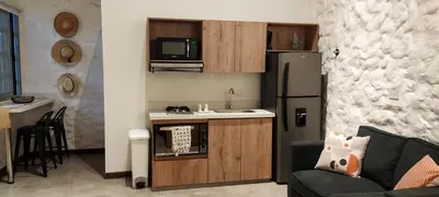 a kitchen with a sink and a refrigerator in a room at La Casa de Nelly - Medellín in Medellín