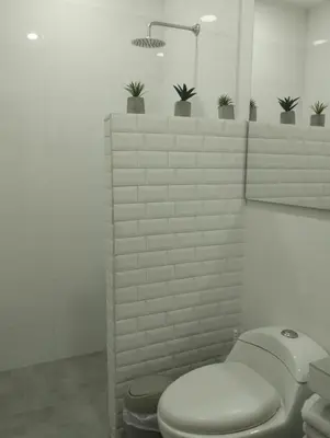 a bathroom with a toilet and plants on a wall at La Casa de Nelly - Medellín in Medellín