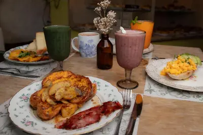a table with two plates of food and two drinks at La Liebre bed and breakfast in El Retiro